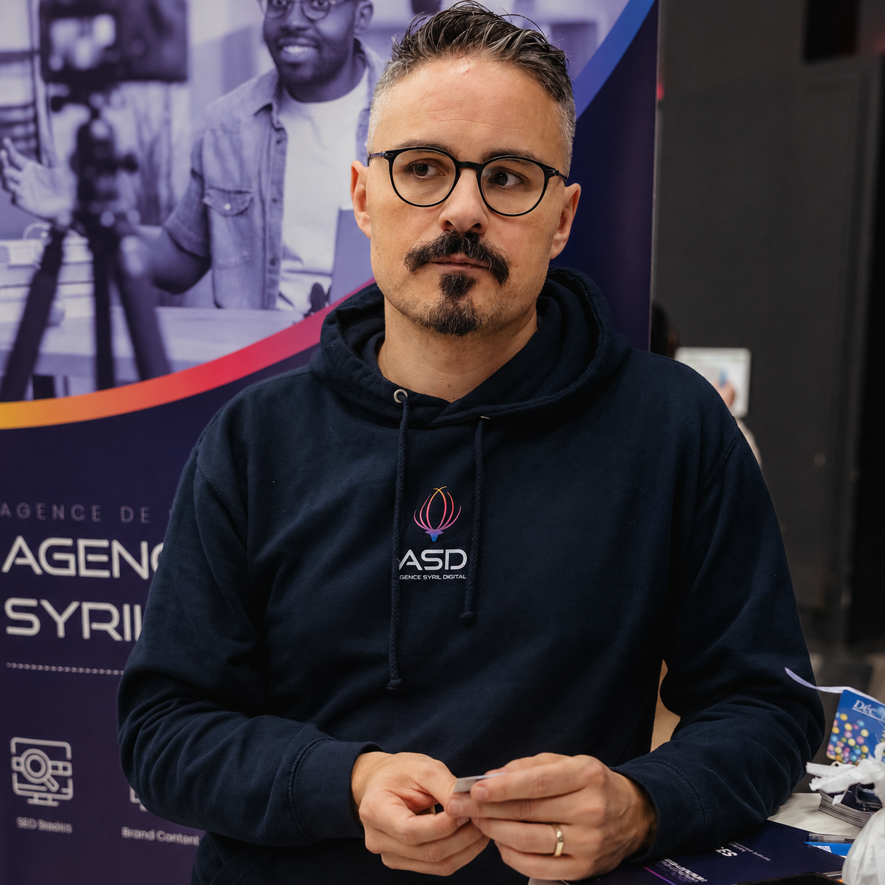 Syril Tiar, founder of a digital marketing agency, standing in front of his agency booth
