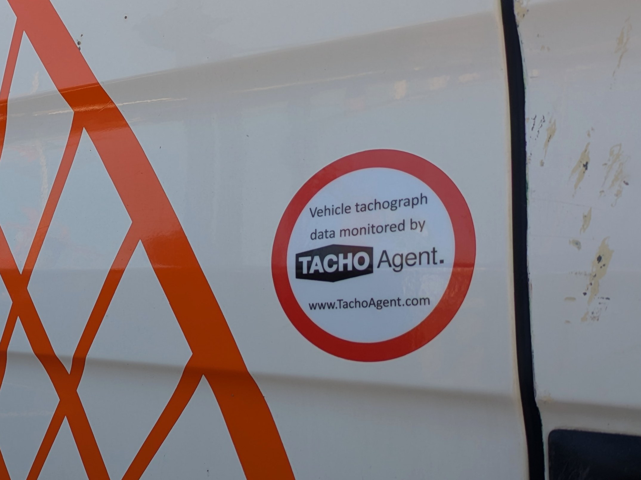 Tacho Agent tachograph monitoring sticker on the drivers door of an HGV
