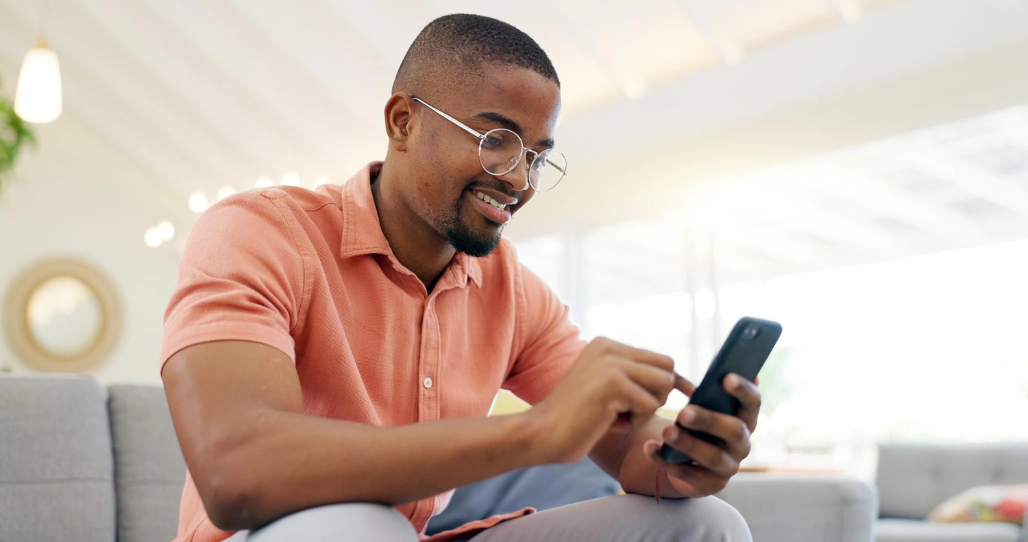 Bottom up view on a Person sitting in a living room scrlling through a phone