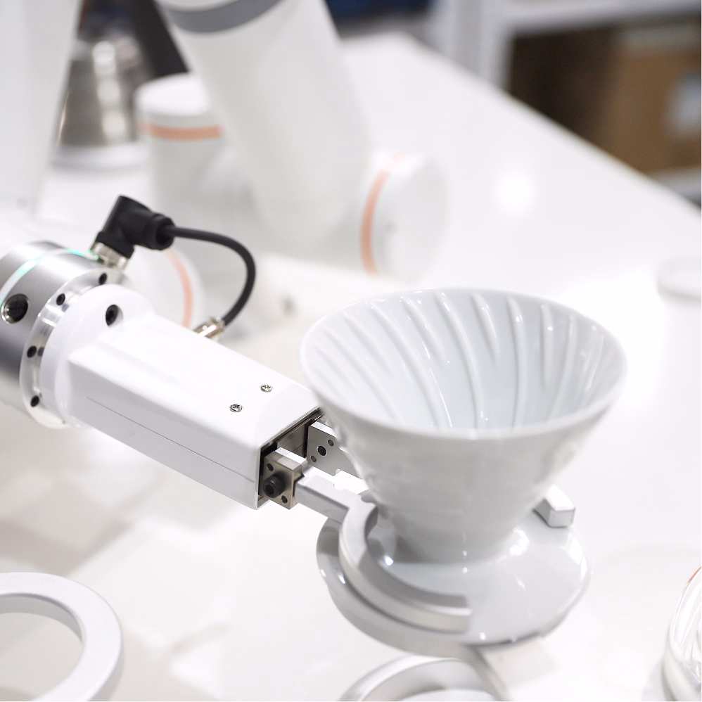 A robotic arm executes a controlled manipulation task within a high-tech laboratory or production environment.