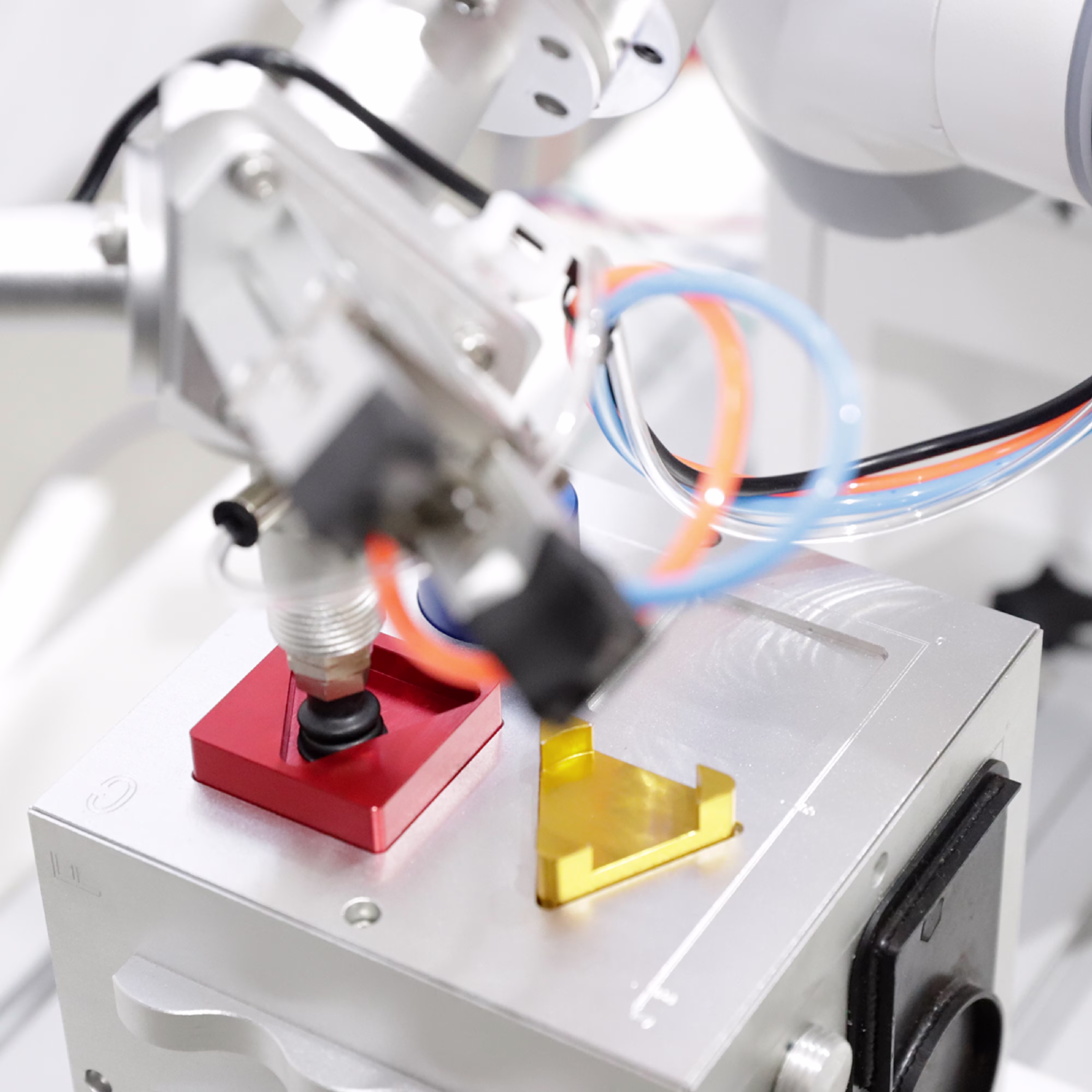 A specialized robotic system interacts with objects in a clean, high-precision environment.