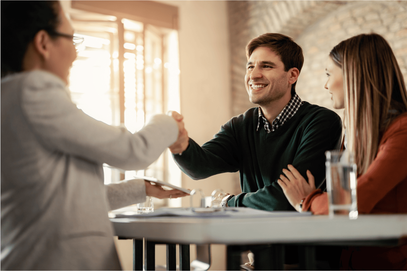 6720f7c1acaf77e94db00662_happy-couple-shaking-hands-with-financial-advisor-meeting-office-focus-is-man 2.png