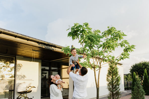 First-time homebuyers standing together outside their new home