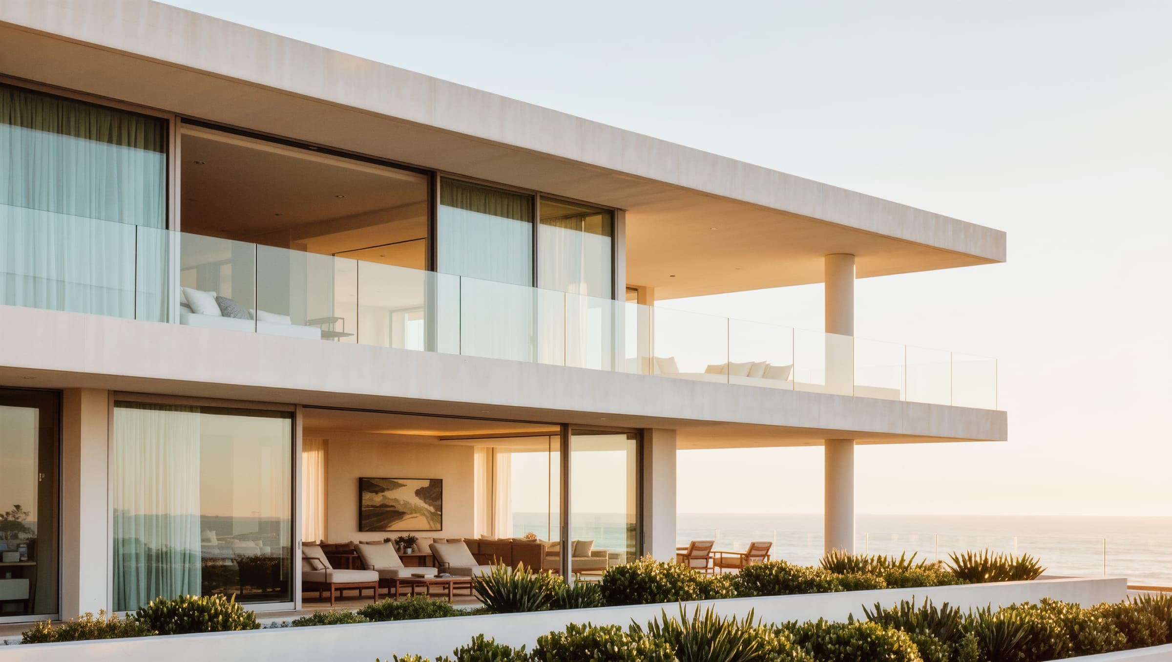 Contemporary coastal second home exterior with a wide balcony under bright sky