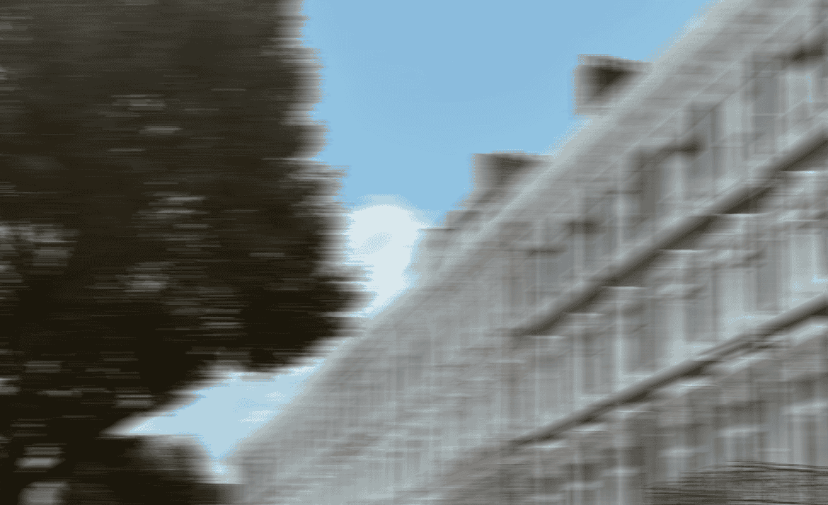 Soft-focus London street with row of houses, trees, and clear blue sky
