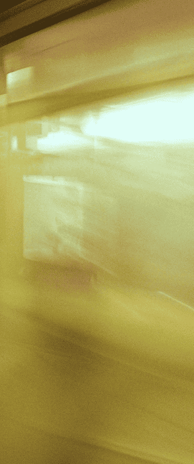 Motion-blurred shot of a subway train passing through a station, lit carriage windows streaking past