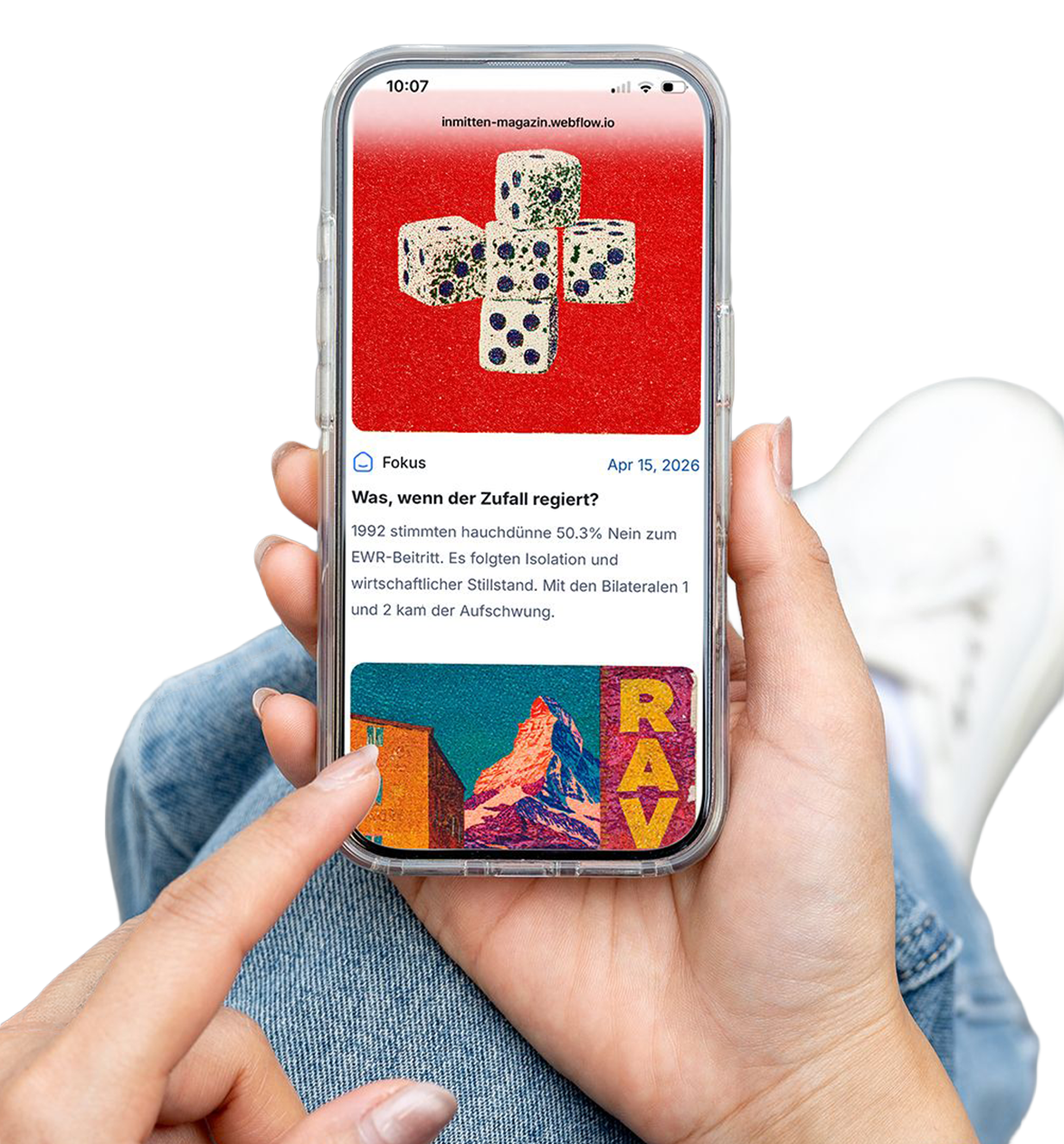 Smartphone in einer Hand vor blauem Hintergrund; auf dem Bildschirm dieses Online-Magazin mit Artikel „Was, wenn der Zufall regiert?“ und Bild von fünf Würfeln auf rotem Hintergrund.