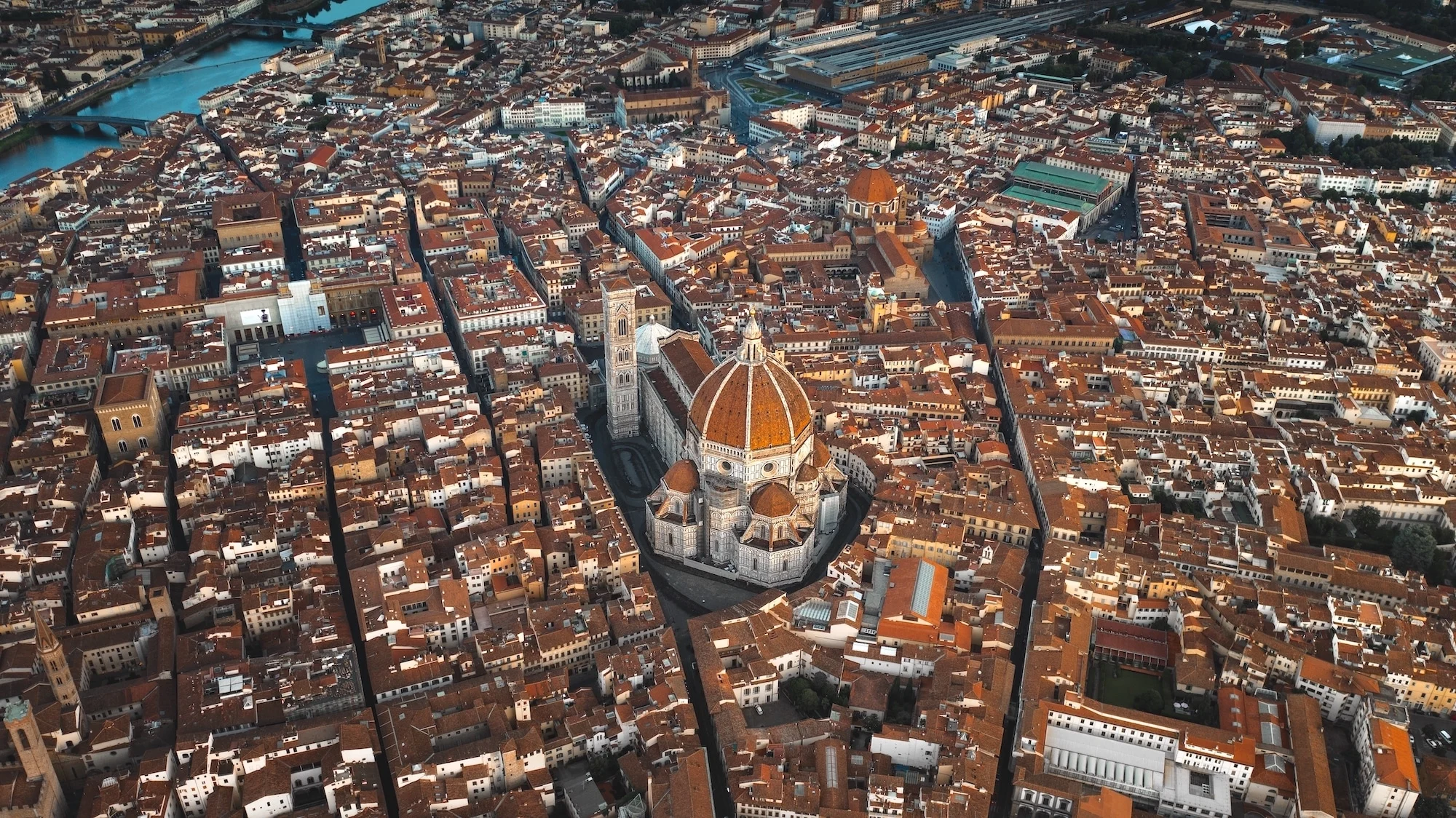 Aerial view of Florence, Italy, highlighting the Florence Cathedral with its iconic red dome and surrounding historic buildings.
