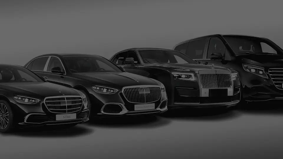 Quatre véhicules noirs de luxe alignés : Mercedes S-Class, Mercedes Maybach, Rolls-Royce et van Mercedes.