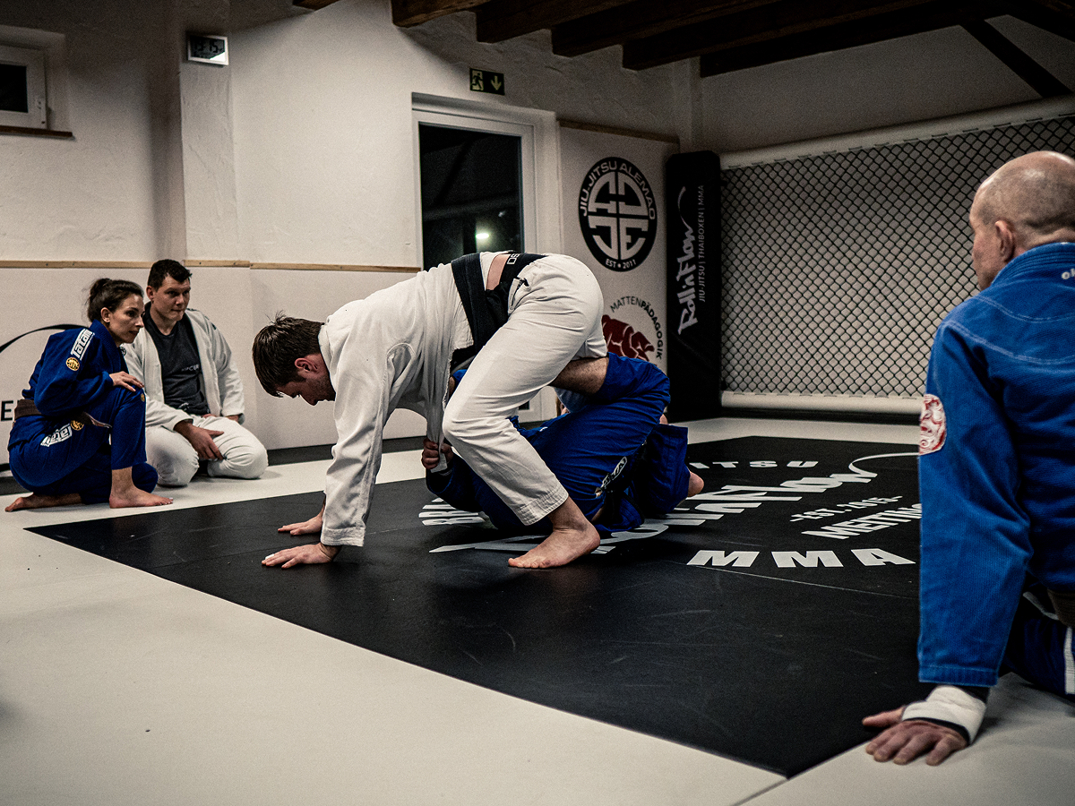 Ein Mann bringt einen anderen Mann mit einer Brazilian Jiu Jitsu Technik aus dem Gleichgewicht.