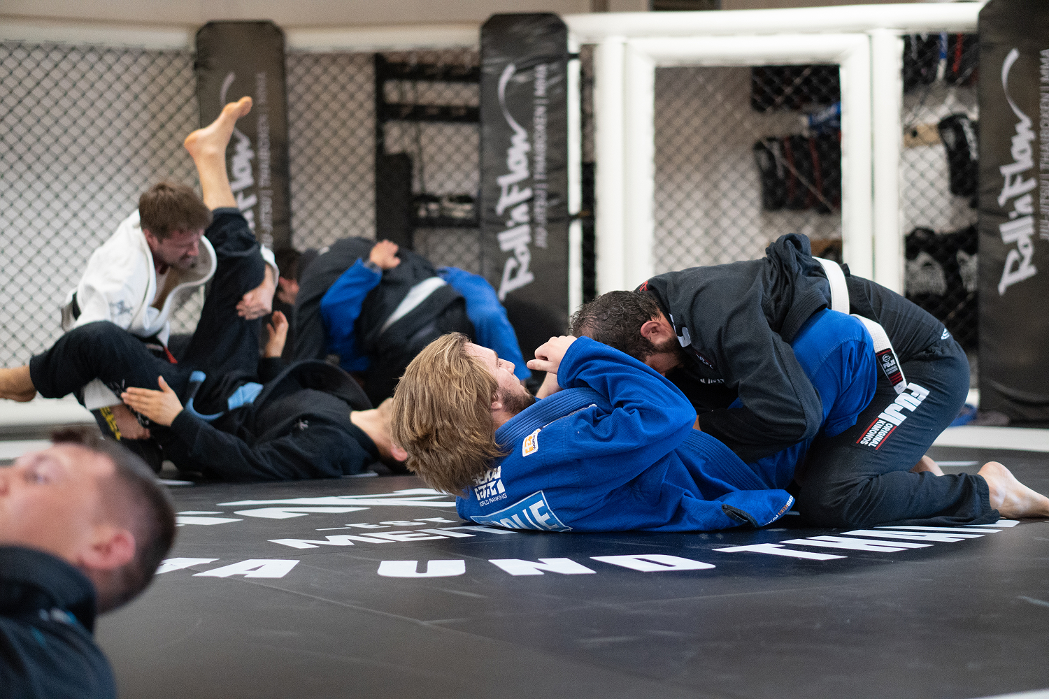 Mehrere Personen trainieren Brazilian Jiu-Jitsu am Boden in der Roll´n Flow Kampfsportschule in Meitingen.