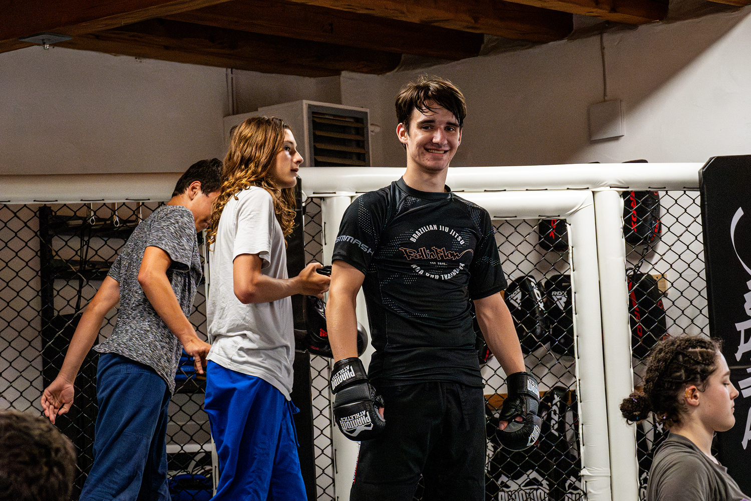 Jugendliche beim Kampfsporttraining mit Handschuhen und sportlicher Kleidung.