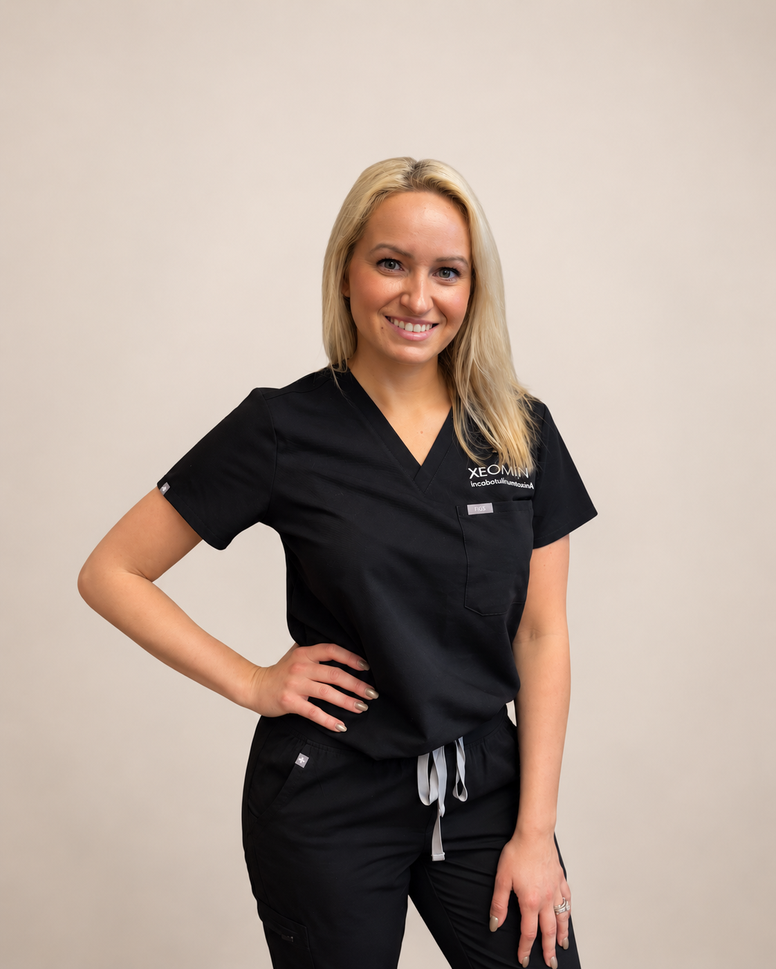 Brittany Holding, MSN, SCRN, FNP-BC, lead instructor at New You Aesthetics Academy, in black scrubs.