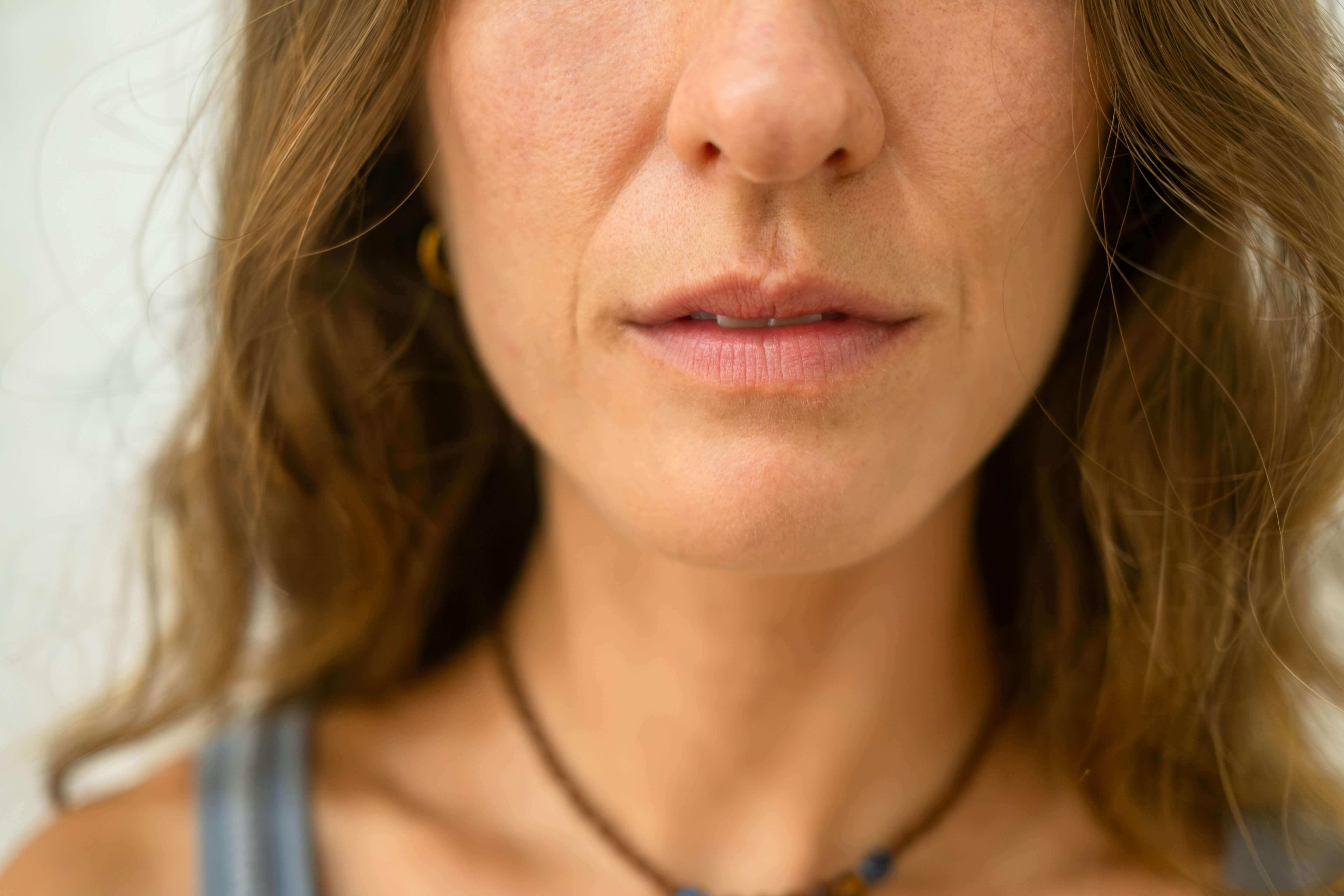 Close-up of mature lips showing fine vertical lip lines that naturally develop with age and collagen loss.