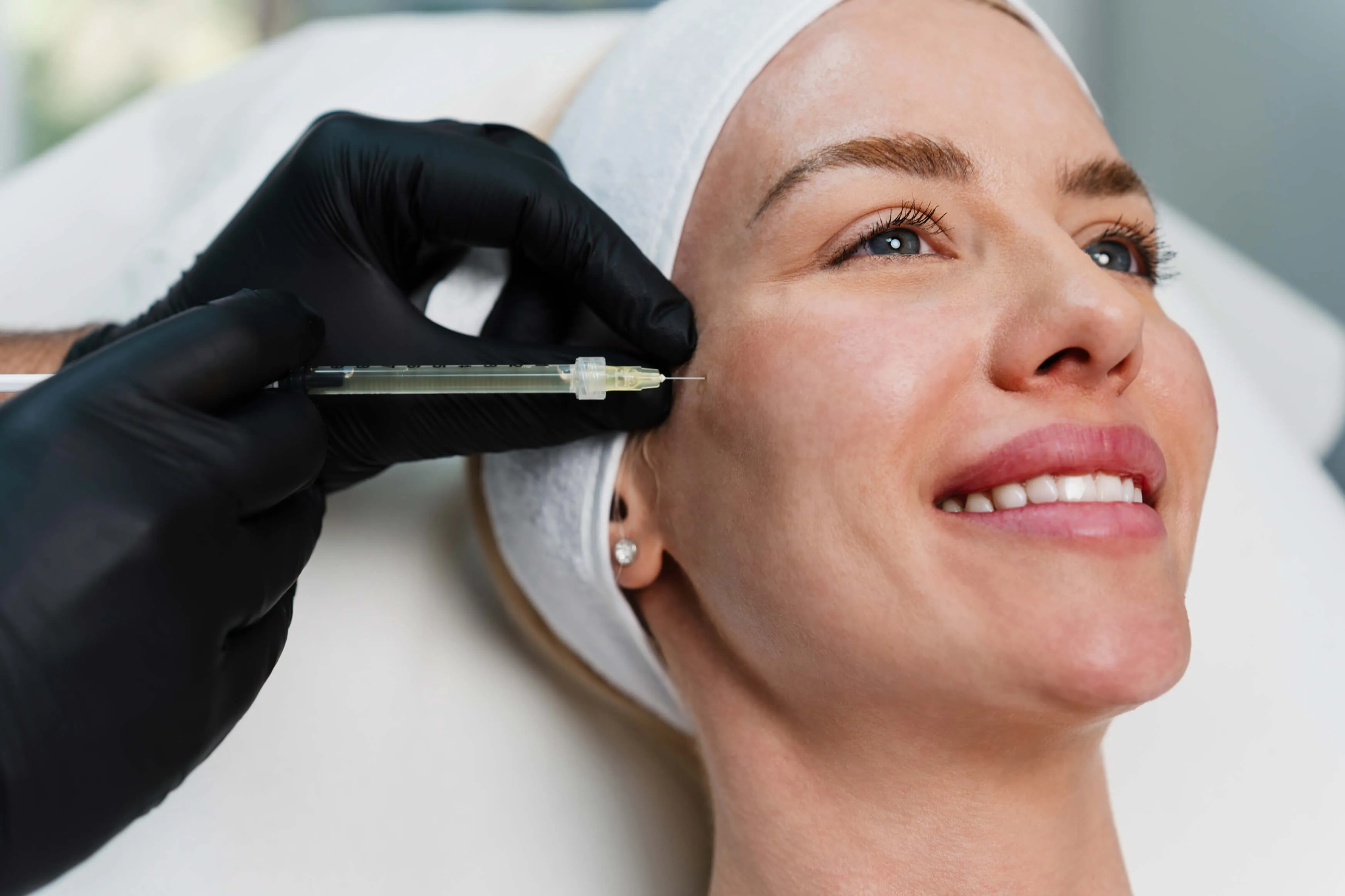 Provider performing a dermal filler injection to enhance cheek volume and improve facial contours