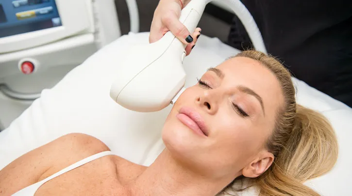 Provider performing an IPL photofacial treatment using Venus Versa system to improve sun damage, age spots, and overall skin tone