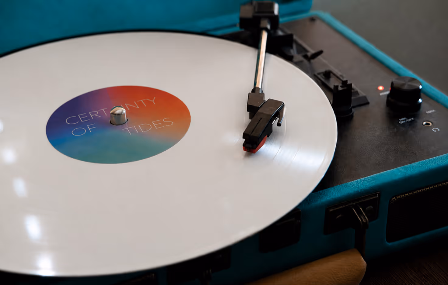 AI Generated image by ChatGpt - White vinyl record titled 'Certainty of Tides' playing on a teal turntable.