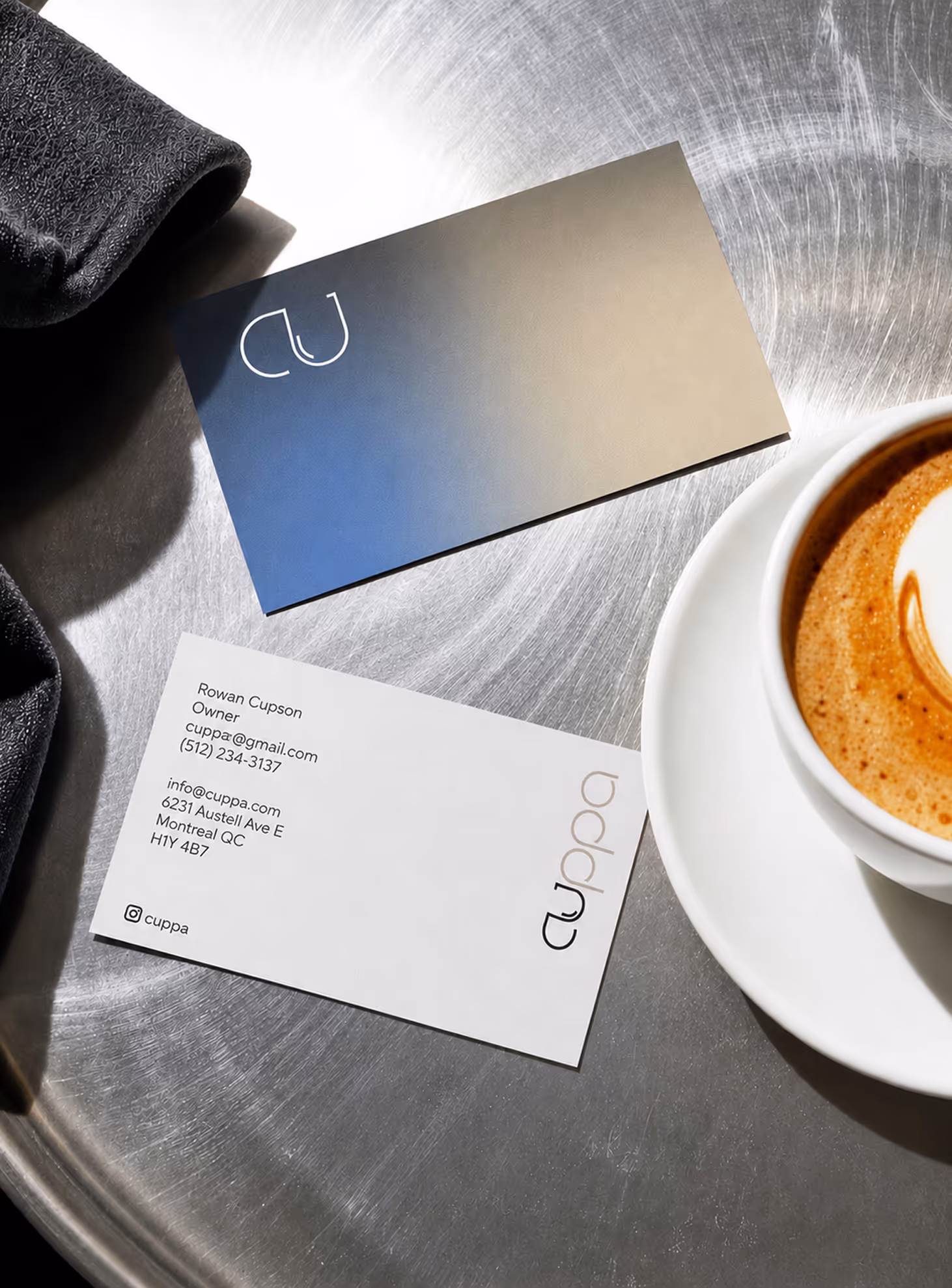 AI Generated image with ChatGpt - Two business cards for Cuppa on a metal surface near a cup of coffee with latte art.