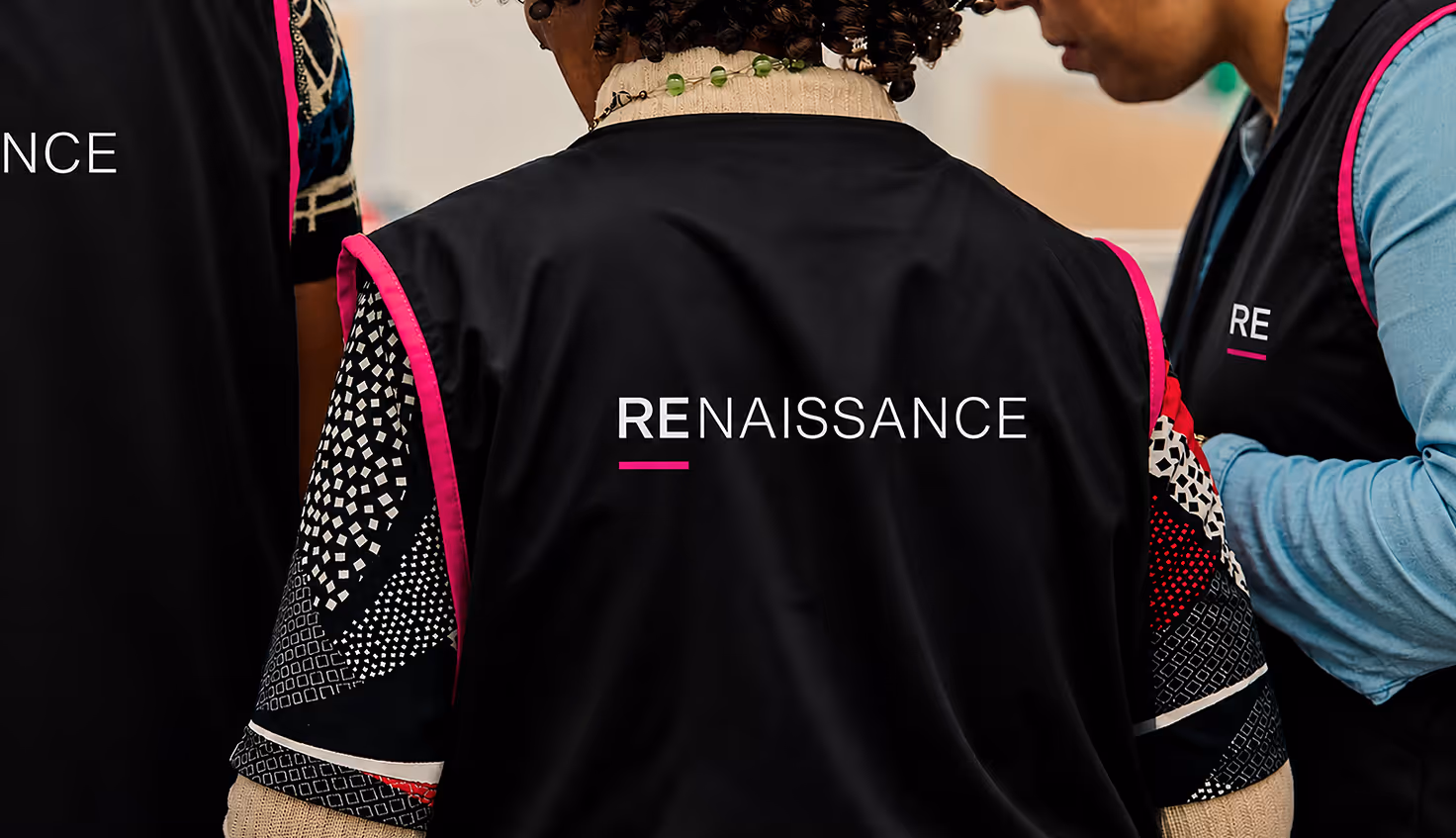 AI Generated image with ChatGpt - Back view of three people wearing black vests with pink trim and the word RENAISSANCE printed on them.