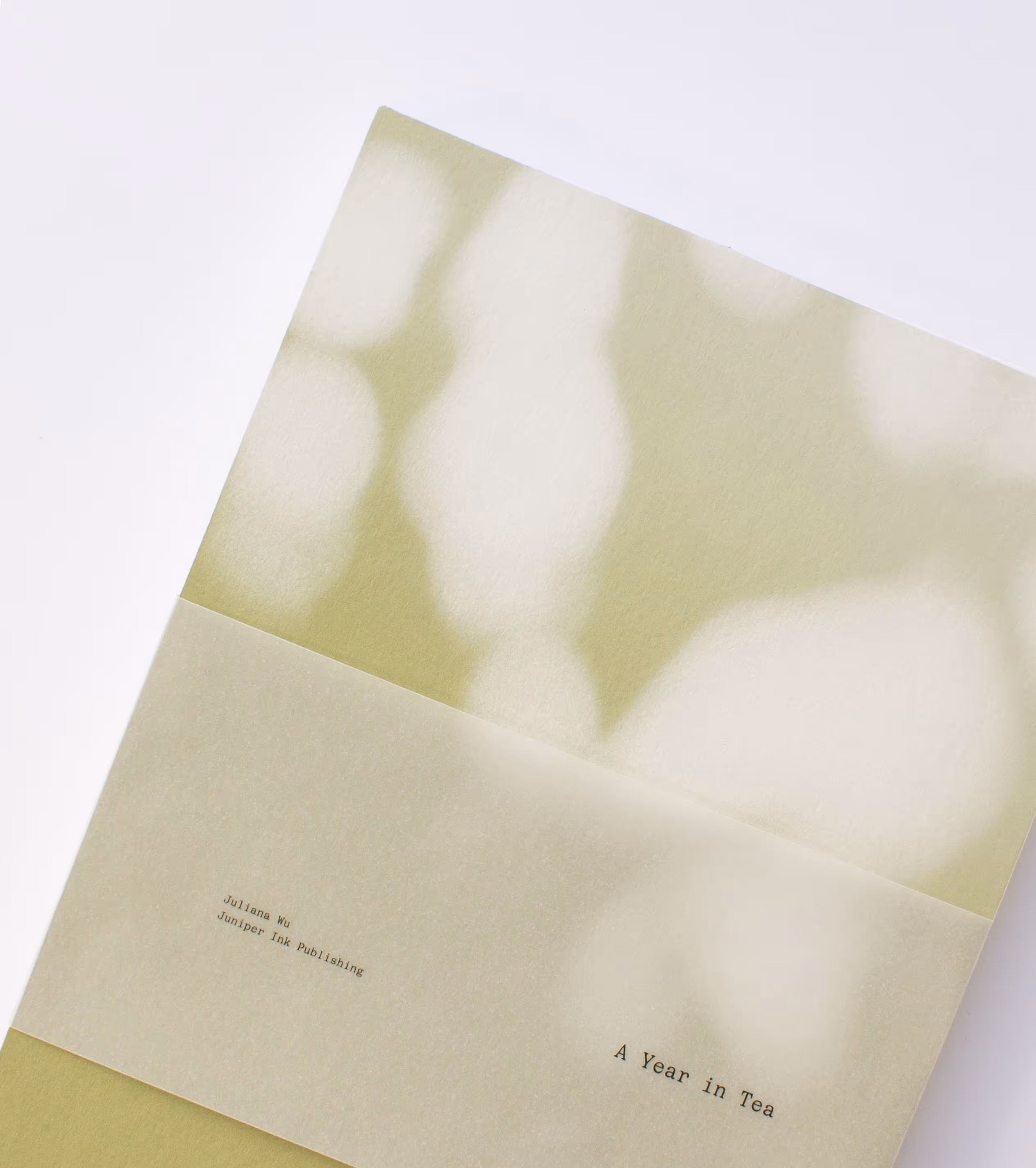 Soft-focus image of a book titled 'A Year in Tea' by Juliana Wu of Juniper Ink Publishing.