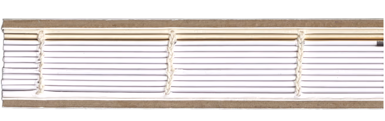 Close-up of a hand-stitched book spine with white thread binding visible between pages.