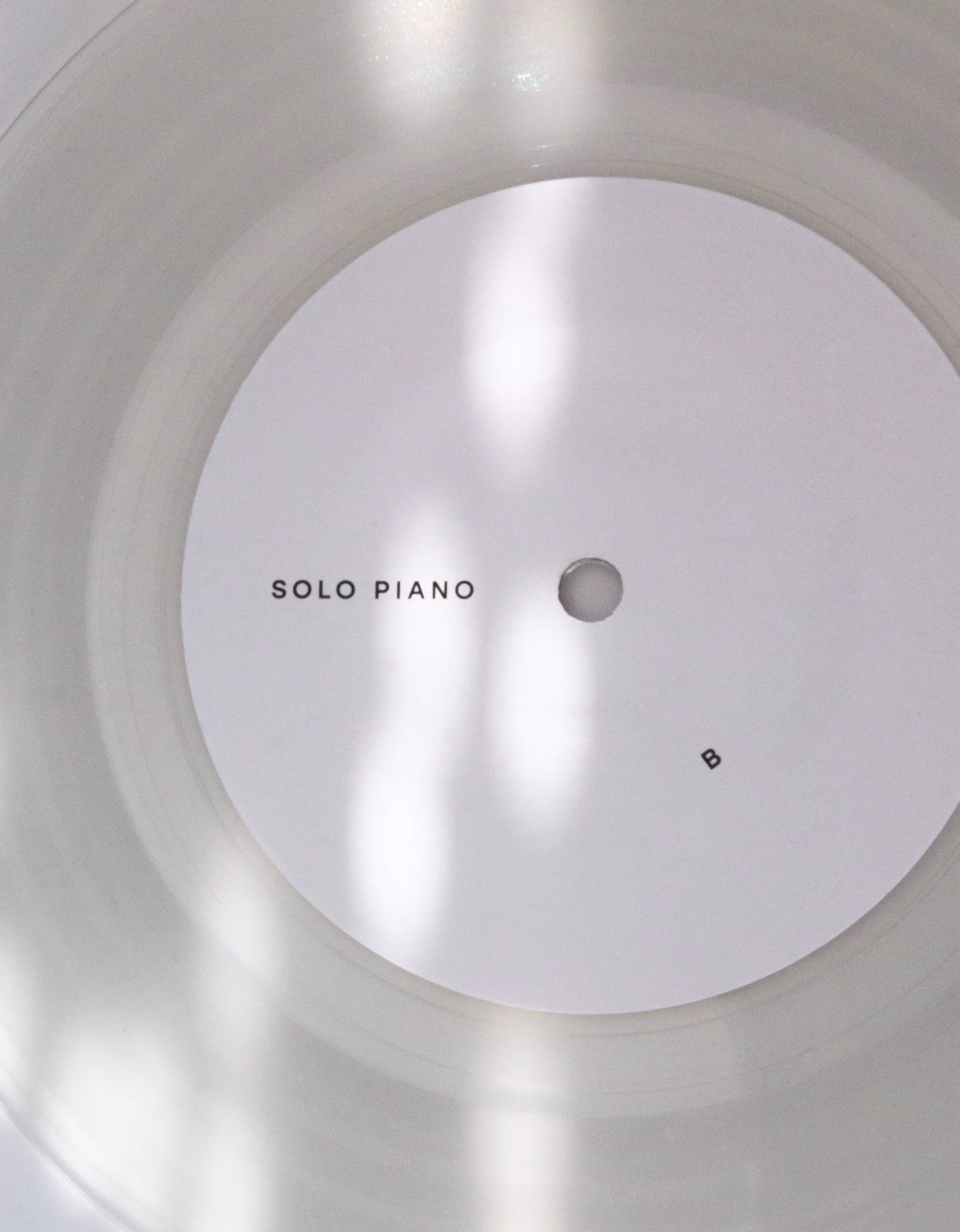 Clear vinyl record with a white label reading 'SOLO PIANO' and letter B on the side.