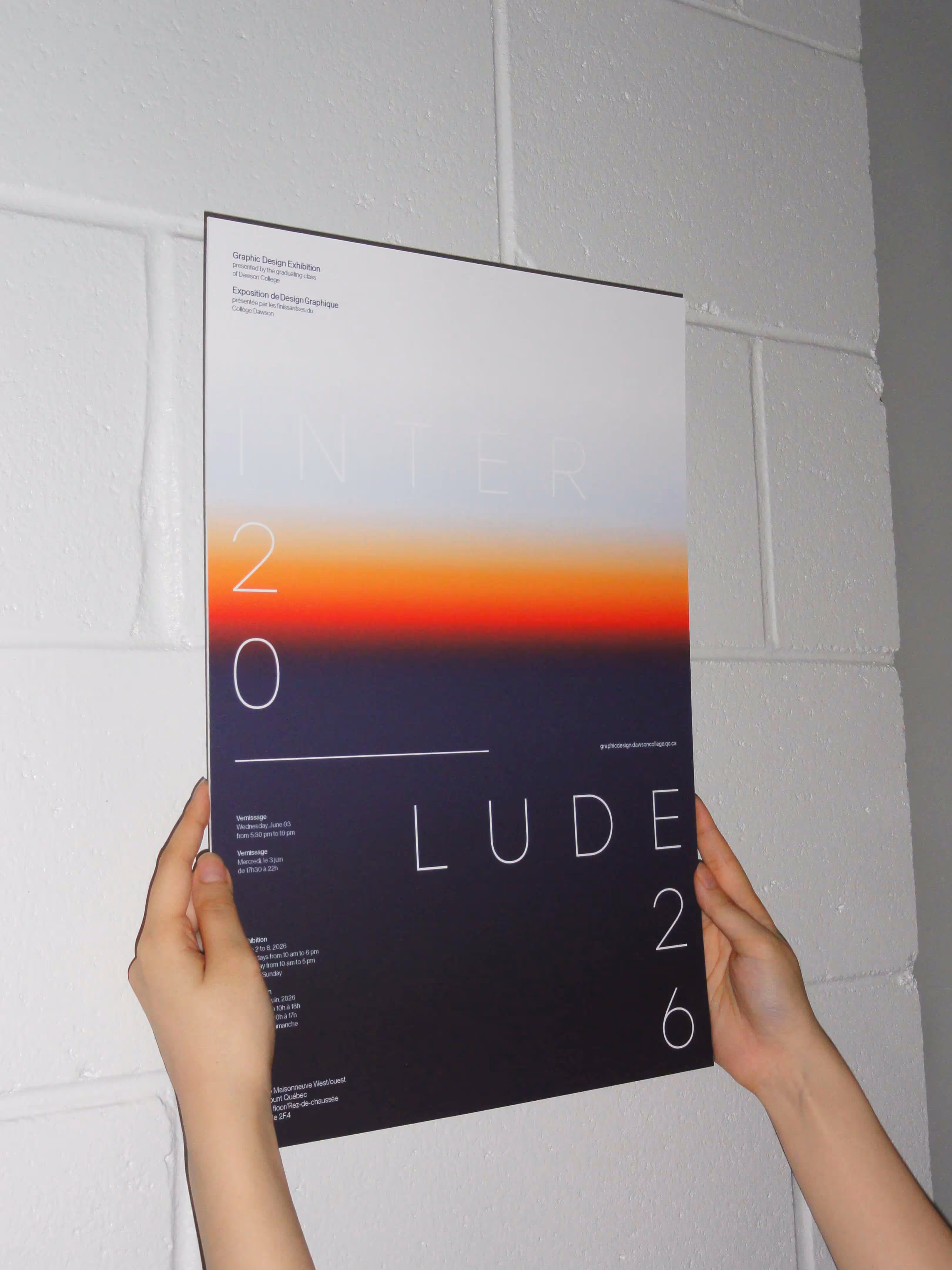 Two hands holding a poster with gradient colors and text about a graphic design exhibition.