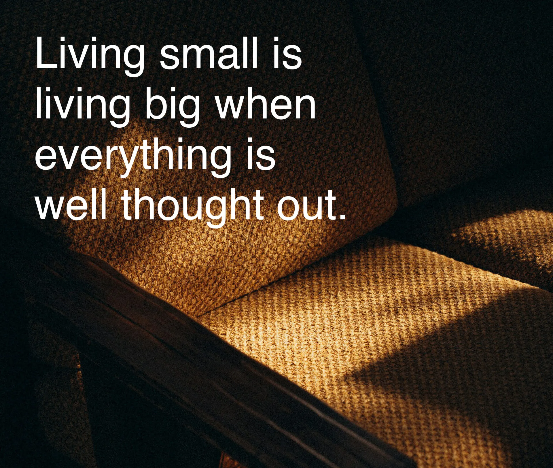 Close-up of a textured brown chair with light casting shadows and the text Living small is living big.