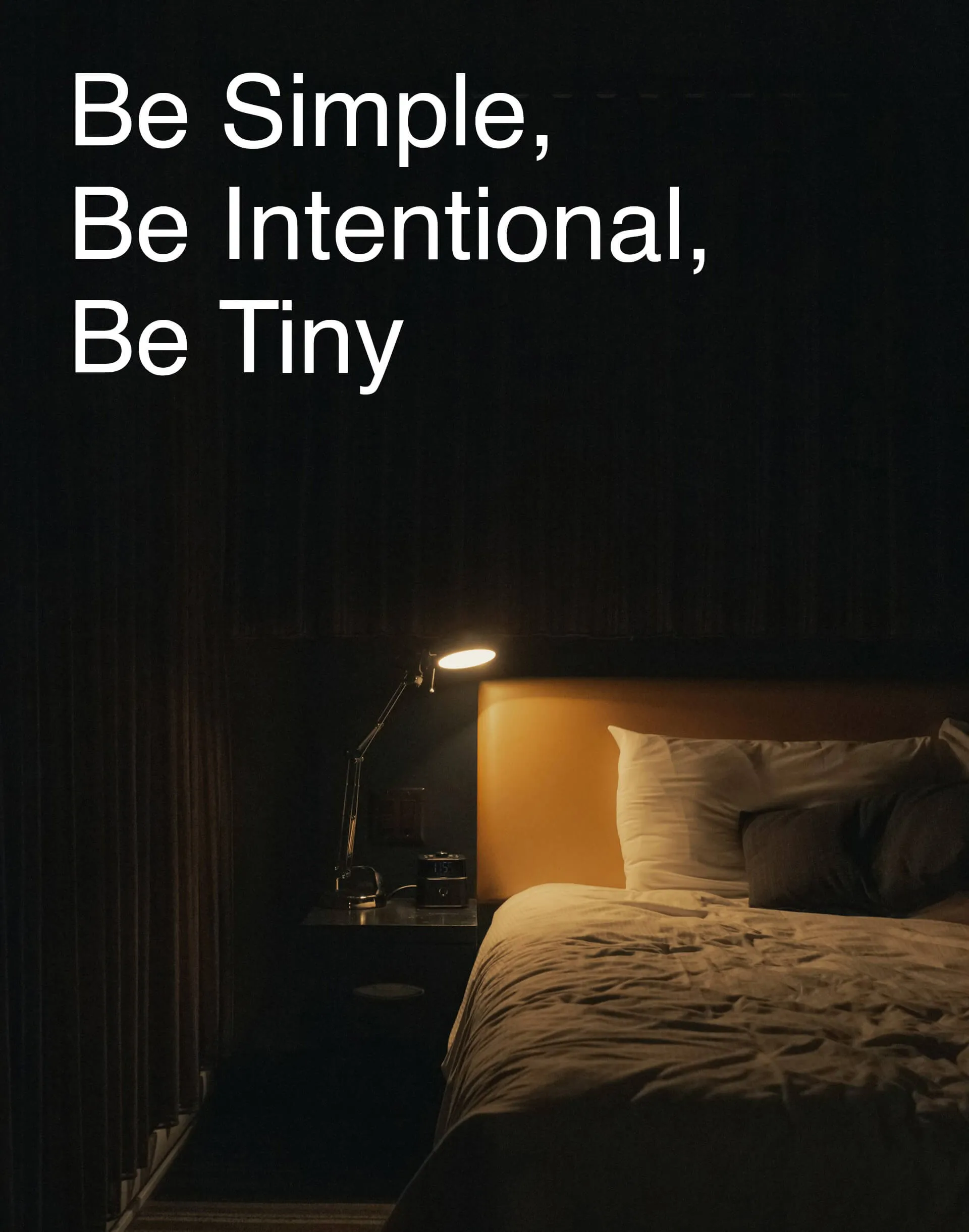 Dimly lit bedroom with a bed, pillows, and a bedside lamp beneath the text Be Simple, Be Intentional, Be Tiny.