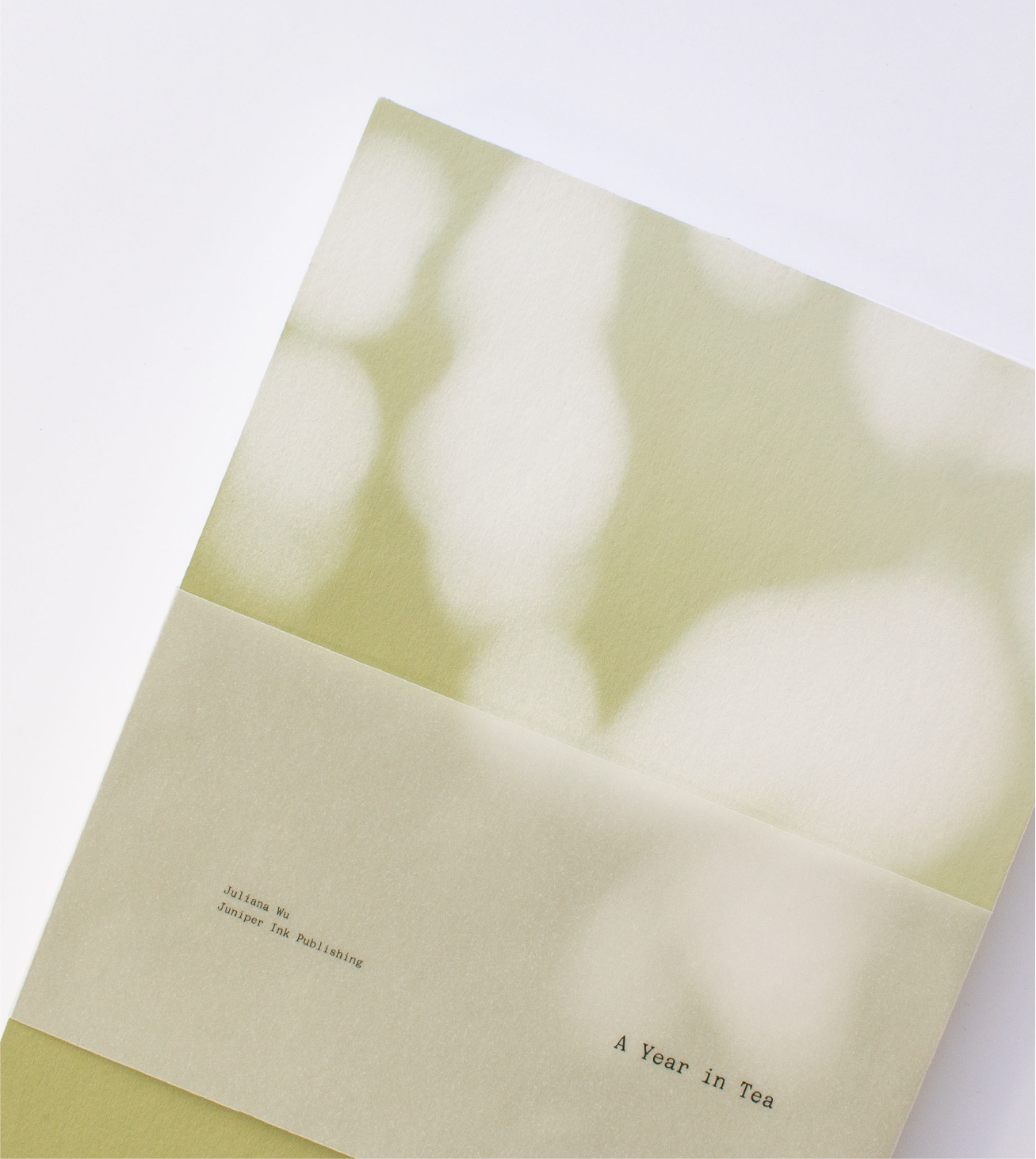 Soft-focus abstract background with text reading 'A Year in Tea' on a pale, folded paper.