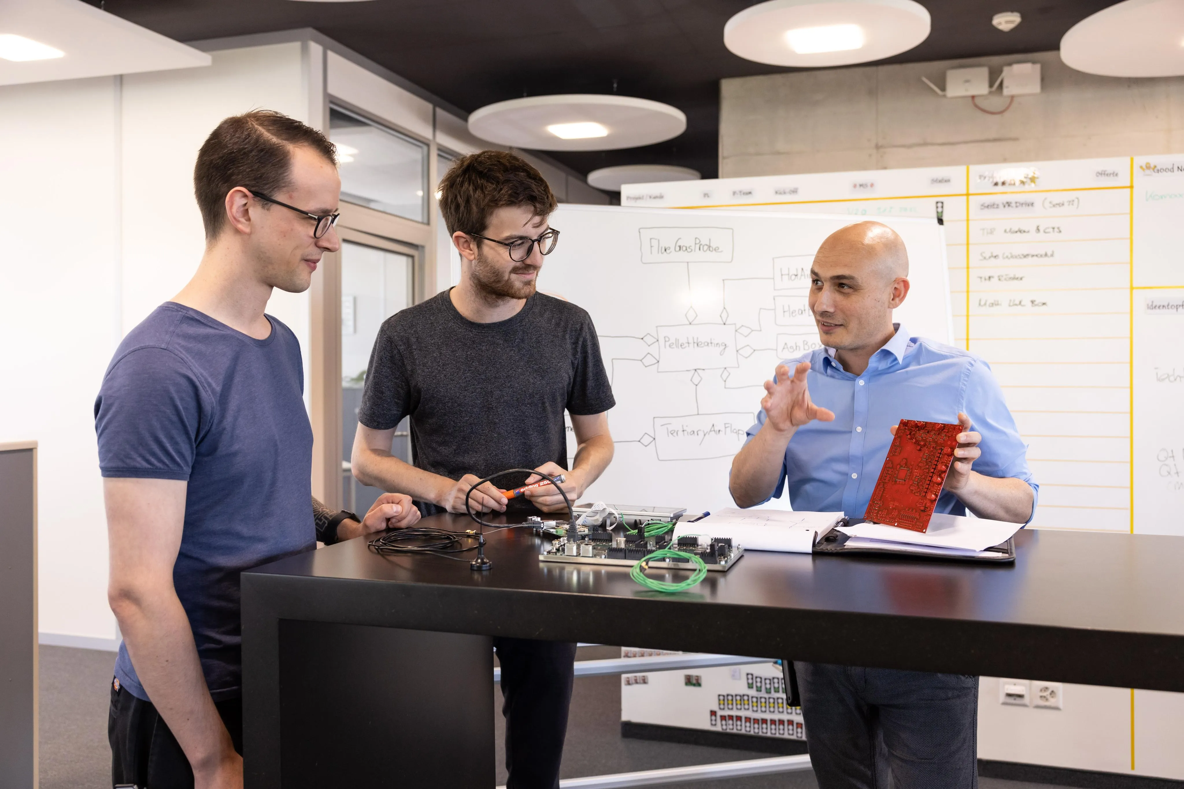 Computechnic AG Team bei der technischen Zusammenarbeit mit Elektronik-Komponenten und Whiteboard