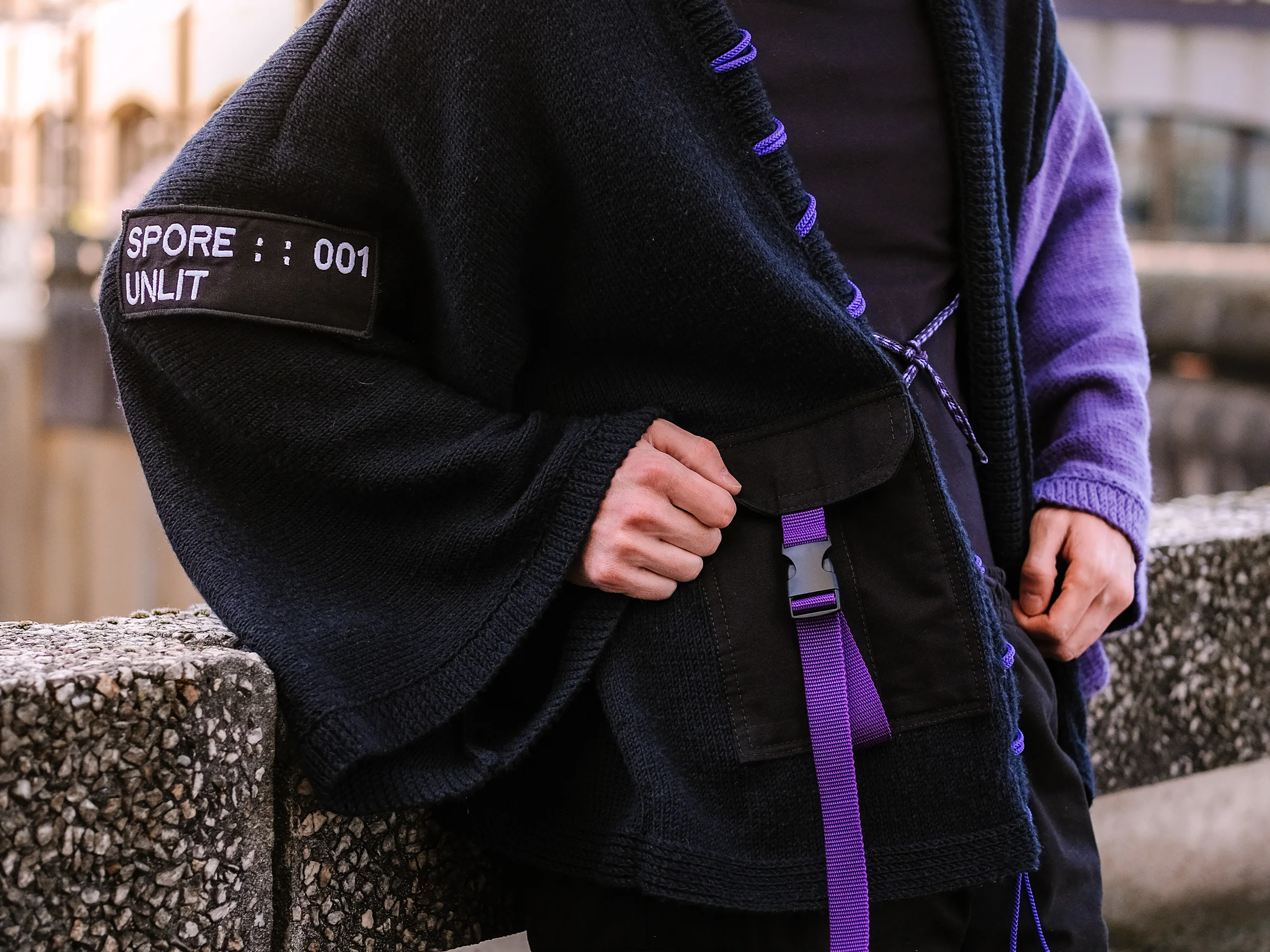 Détail porté du kimono artisanal Nox I : patch SPORE :: 001, poche plaquée et boucle violette