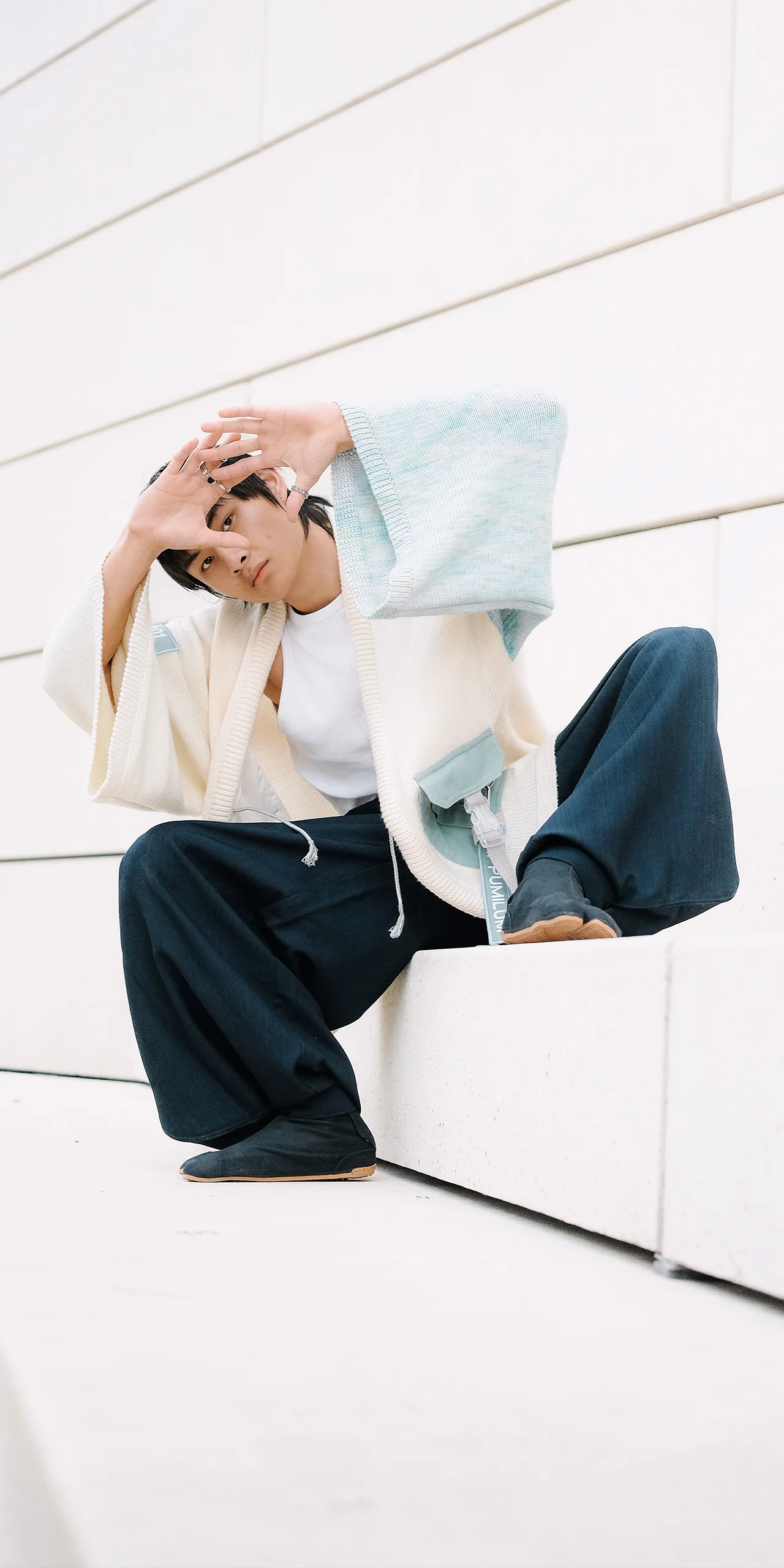 Kimono Lux en mérinos éthique blanc écru et bleu boréal porté accroupi, jet tag PUMILUM