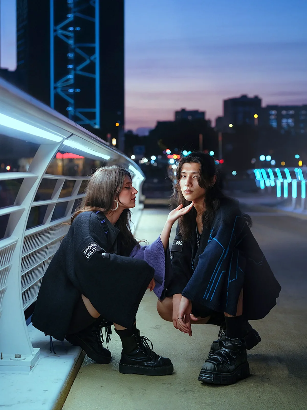 Deux personnes en kimonos Nox face à face sur une passerelle éclairée au crépuscule, tricot artisanal Procyon