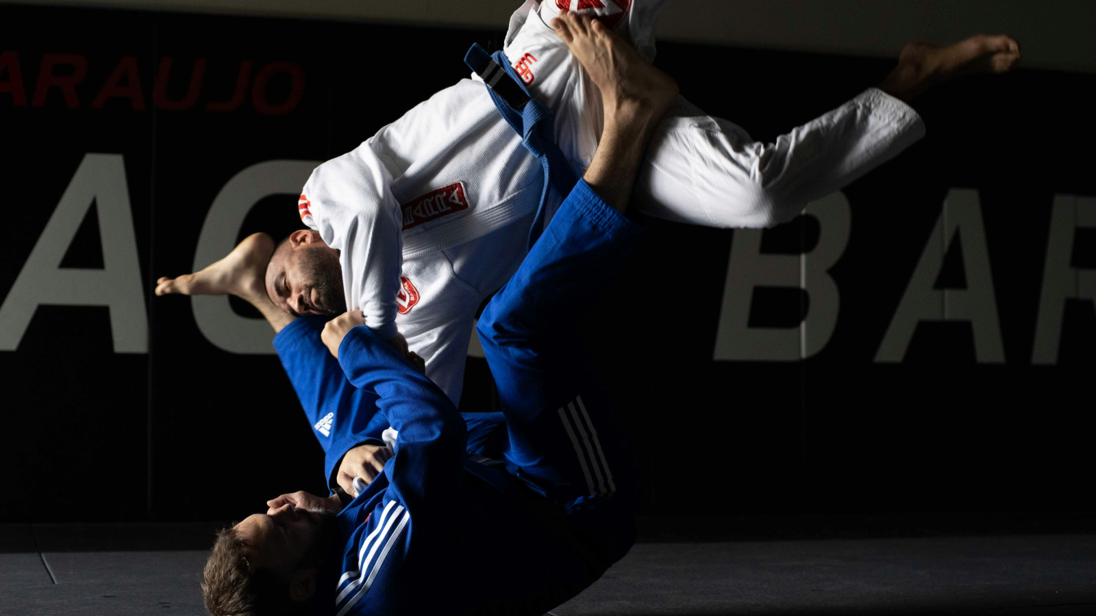 A solo grappler on a training mat photographed in a calm, documentary style representing deliberate and patient training.