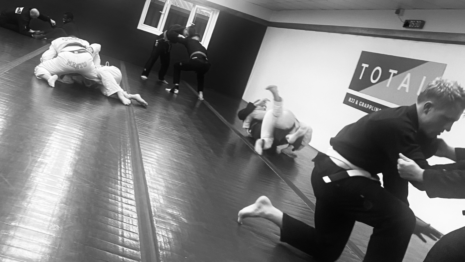 A solo grappler on a training mat, photographed in a calm documentary style representing consistent practice.
