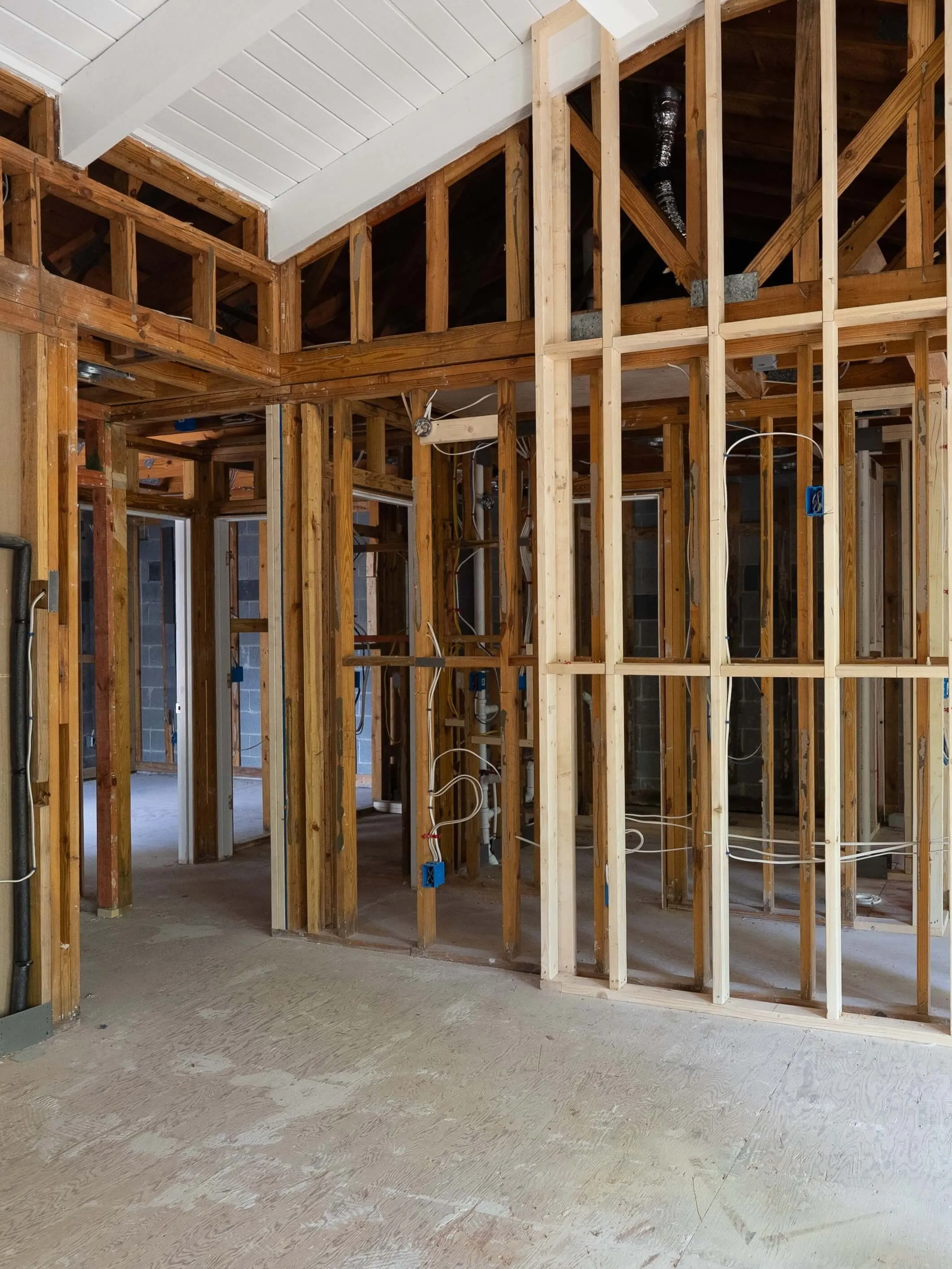 Interior of a house under construction showing wooden framing and electrical wiring.
