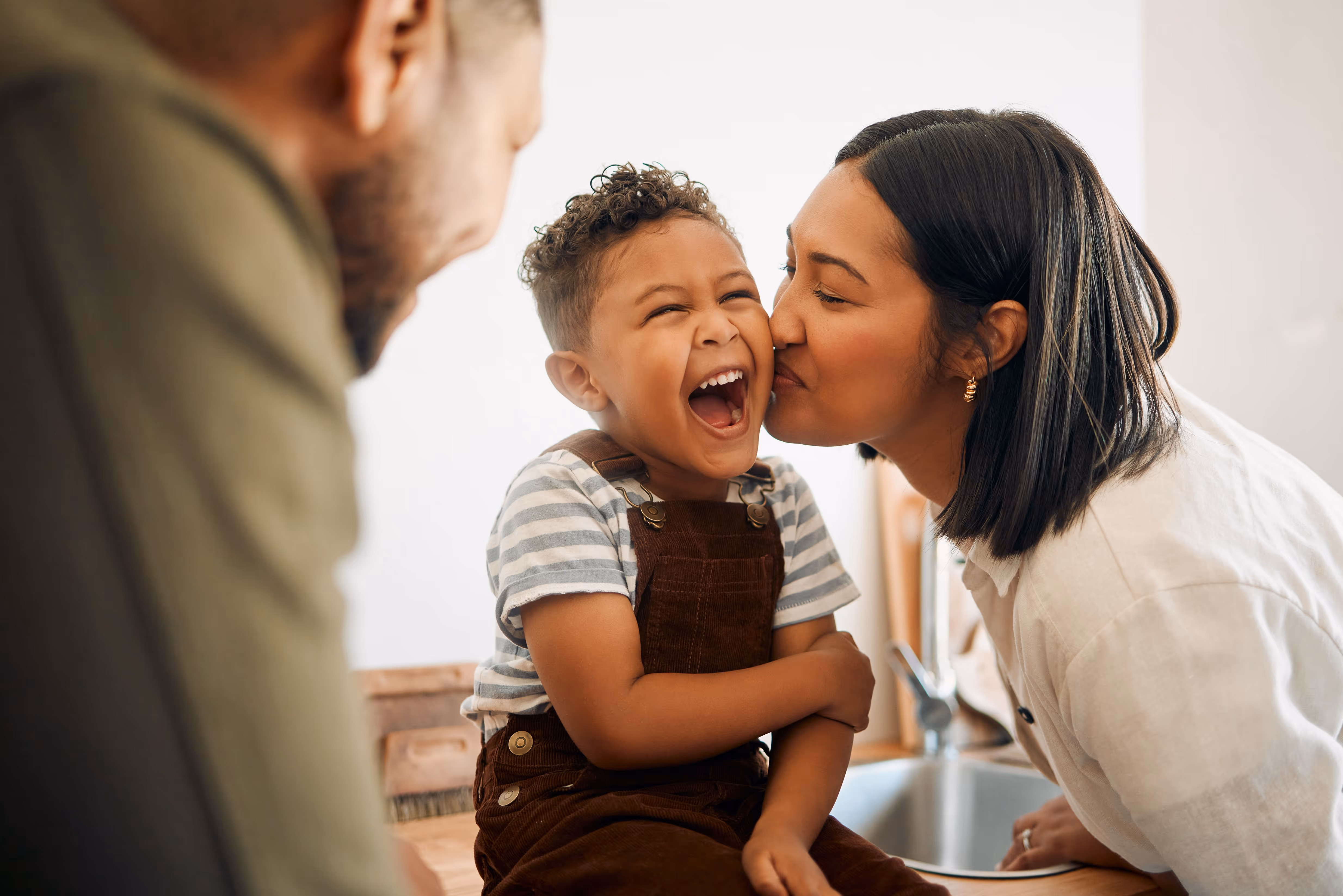 Mom kissing son on the cheek stock image