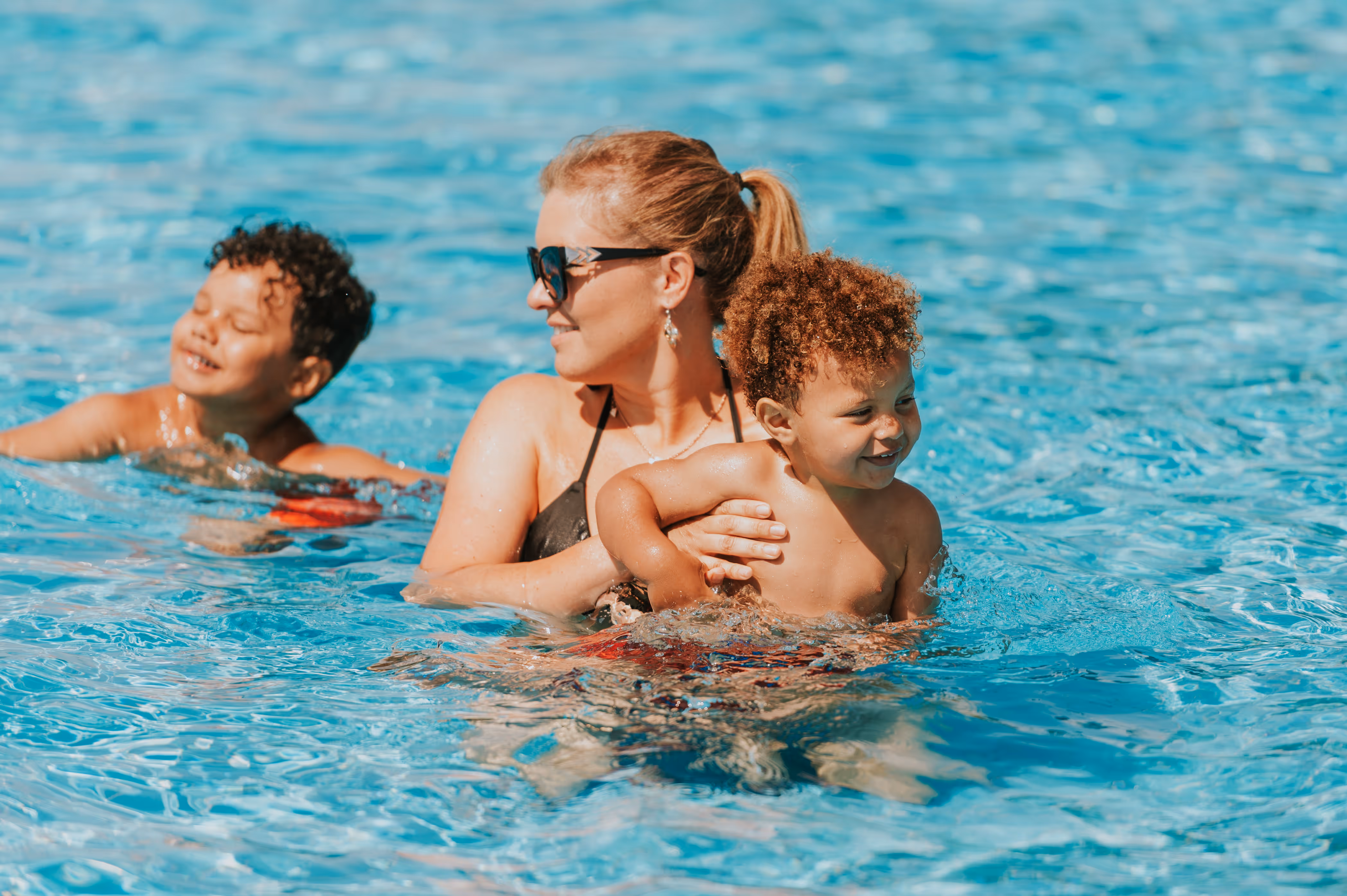 Mom and kids in the pool stock image