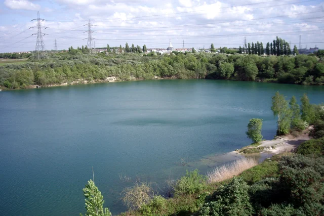Lake in a former chalk quarry surrounded by trees and scrub in Thurrock