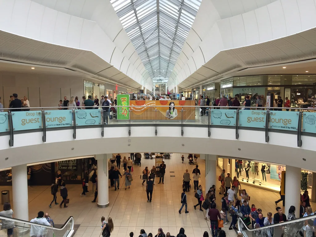 Shoppers on two levels under the glass roof inside Lakeside Shopping Centre