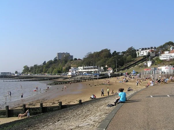 Sunny beach and promenade on Southend seafront with the cliffs and houses behind
