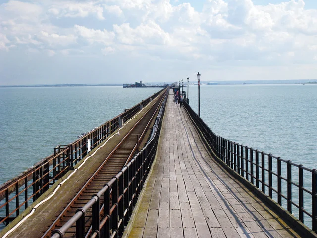 Wooden walkway and railway track running along Southend Pier out into the estuary