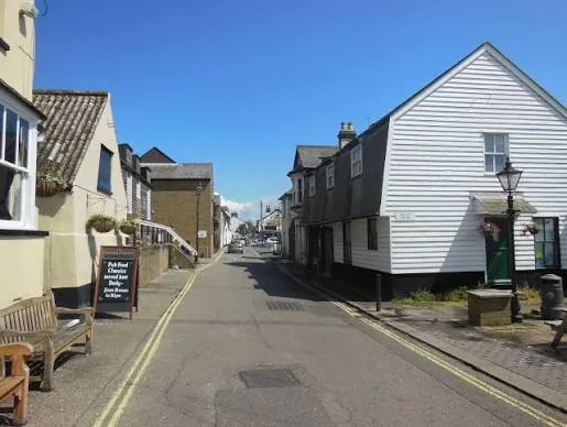 Narrow street of white weatherboarded and period buildings in Old Leigh