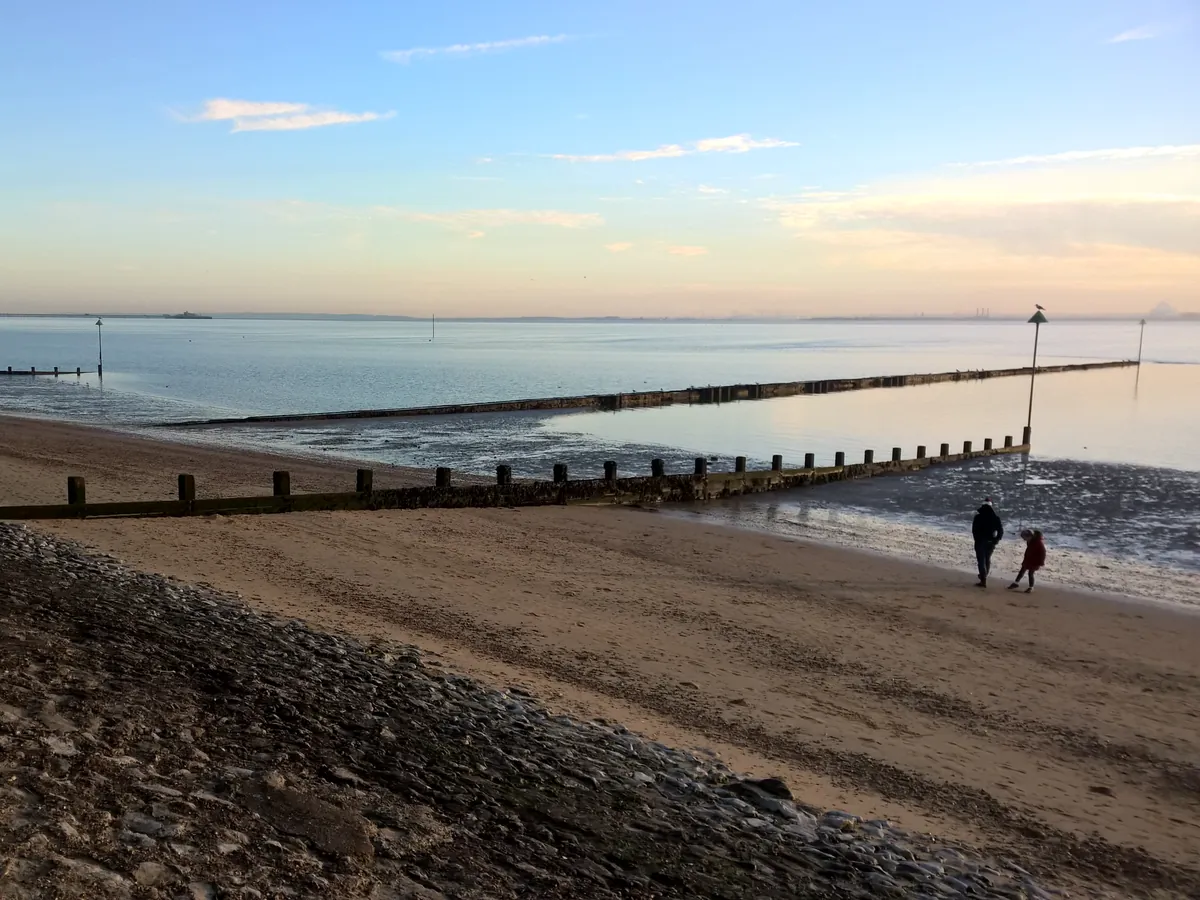 Evening light over Chalkwell beach and groynes with Southend Pier on the horizon