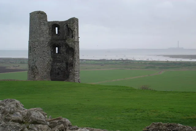 Ruined tower of Hadleigh Castle above green fields and the Thames Estuary