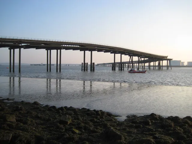 Long jetty on stilts crossing the estuary at low tide off Canvey Island