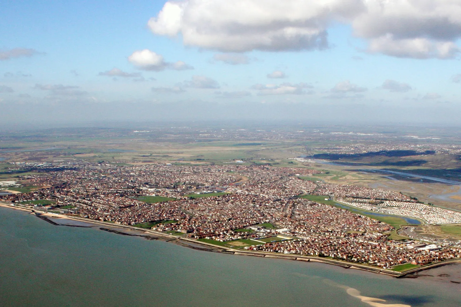 Aerial view of Canvey Island's homes and sea wall along the Thames Estuary