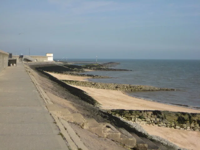 Canvey Island seafront path along the sea wall above the beach and rock groynes