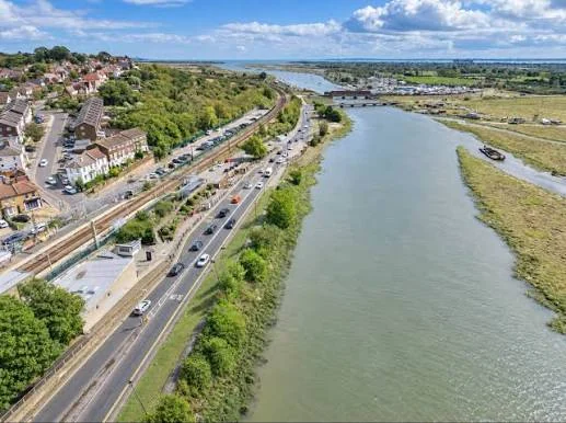 Aerial view of Benfleet Creek beside Ferry Road and the railway line, with the estuary beyond